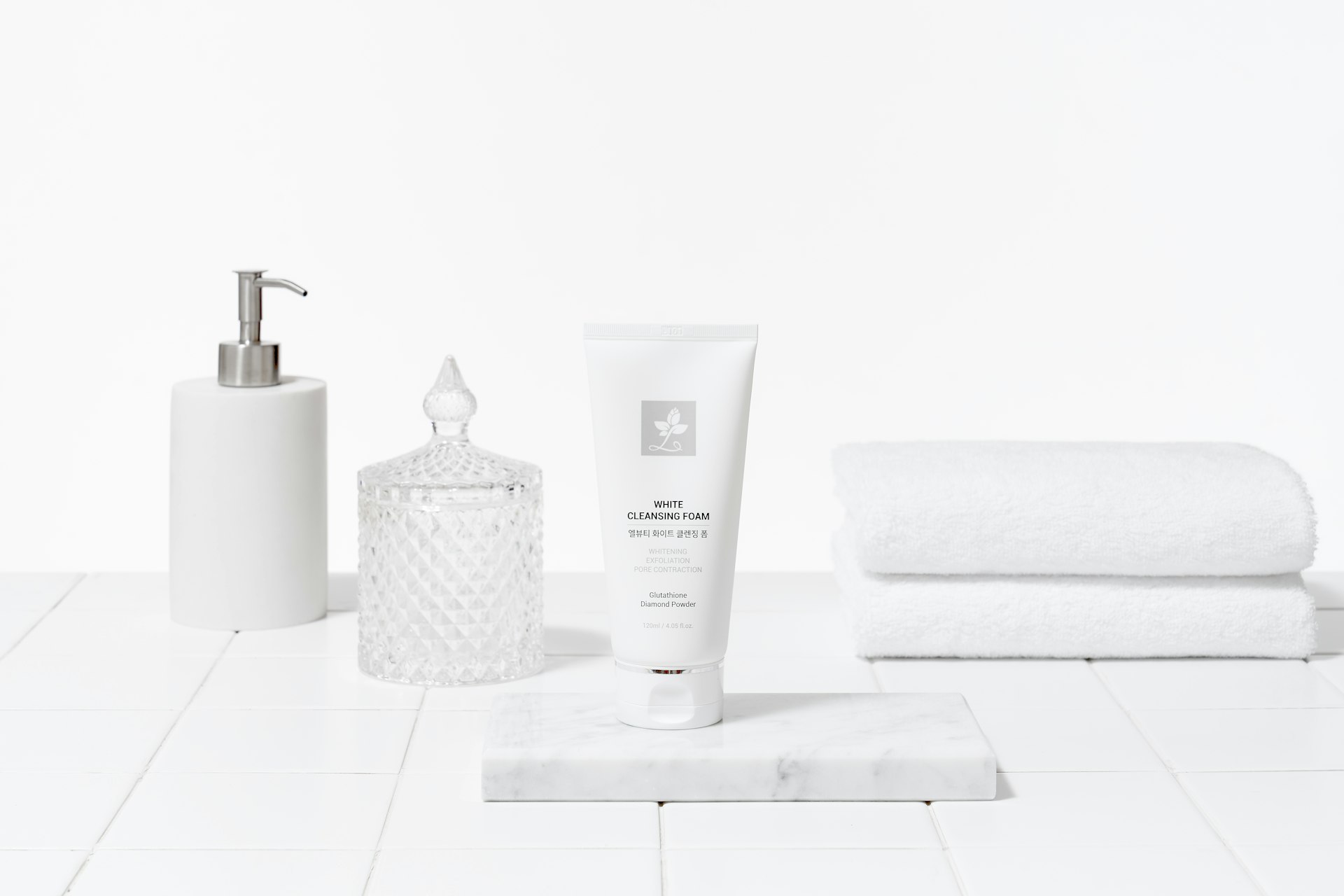 a white bathroom with a lotion bottle, soap dispenser, and